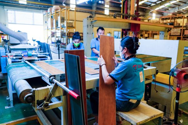 Modern SPC flooring manufacturing facility comparing Vietnam, China, and Thailand as global sourcing destinations for import buyers.